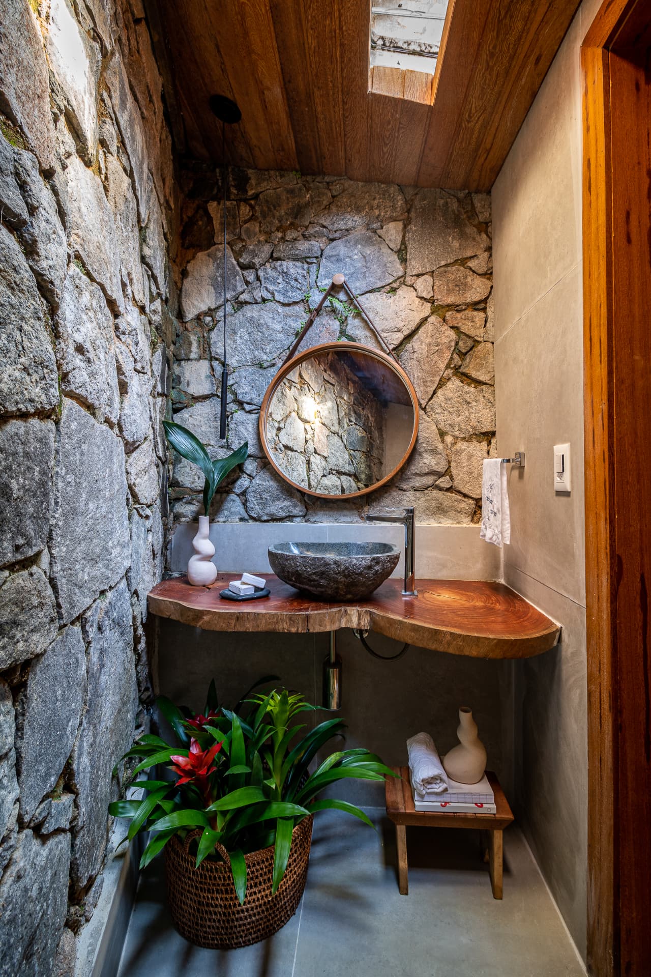 Lavabo com cuba de pedra bruta e rocha nua