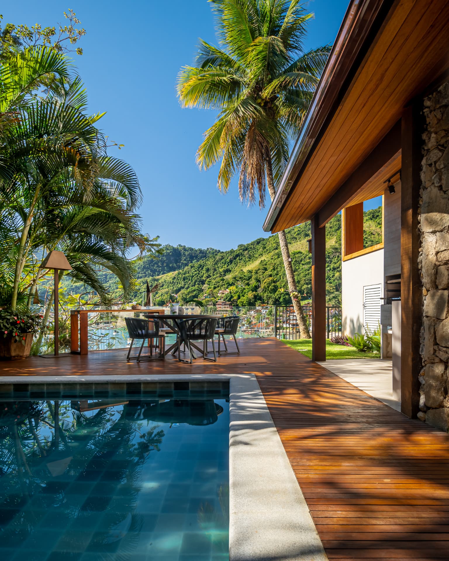 Deck de madeira e piscina em tons profundos de azul