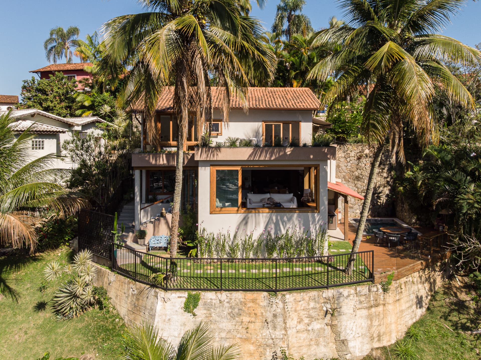 Implantação na encosta, entre coqueiros e a baía